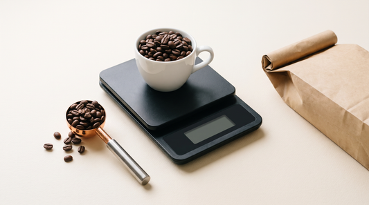 Digitale weegschaal met een kop koffiebonen en een maatschepje, om te bepalen hoeveel gram koffie per kop je nodig hebt